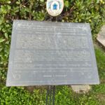Targa commemorativa in metallo con iscrizione posta su un supporto